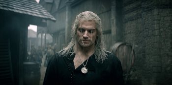 Movie still from “The Witcher” (2019), created by Lauren Schmidt Hissrich – A man with long white hair wearing a black shirt; Close Up shot, Low angle