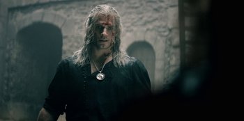 Movie still from “The Witcher” (2019), created by Lauren Schmidt Hissrich – A man in a black shirt with a scar on his face; Close Up shot, Over the shoulder angle