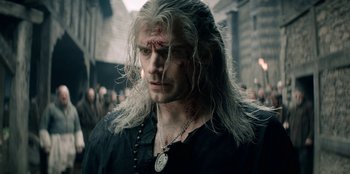Movie still from “The Witcher” (2019), created by Lauren Schmidt Hissrich – A person wearing a necklace; Close Up shot, Over the shoulder angle