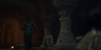 Movie still from “The Witcher” (2019), created by Lauren Schmidt Hissrich – A man standing in front of some pillars; Wide shot, Low angle