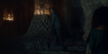 Movie still from “The Witcher” (2019), created by Lauren Schmidt Hissrich – A man standing in front of a pile of skulls; Wide shot, Low angle