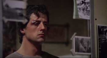 Movie still from “Rocky” (1976), directed by John G. Avildsen – A person with makeup on his face; Close Up shot, Over the shoulder angle