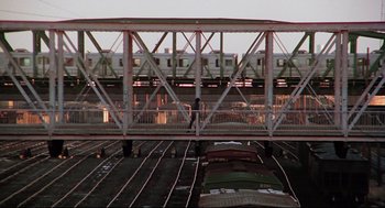 Movie still from “Rocky” (1976), directed by John G. Avildsen – A train on a bridge over a train track; Extreme Wide shot, Low angle