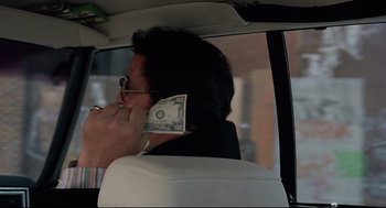 Movie still from “Rocky” (1976), directed by John G. Avildsen – A man in a car talking on a cell phone; Close Up shot, Over the shoulder angle