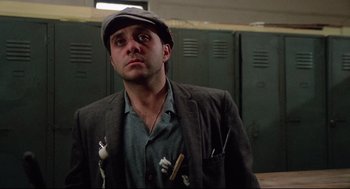 Movie still from “Rocky” (1976), directed by John G. Avildsen – A man in a hat and jacket looking to his left; Close Up shot, Low angle