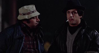 Movie still from “Rocky” (1976), directed by John G. Avildsen – A couple of men standing next to each other; Close Up shot, Low angle