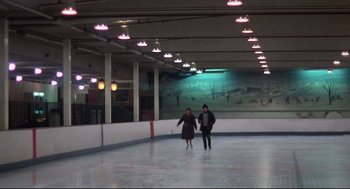 Movie still from “Rocky” (1976), directed by John G. Avildsen – Two people are skating in an indoor rink; Extreme Wide shot, High angle
