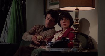 Movie still from “Rocky” (1976), directed by John G. Avildsen – A man and a woman sitting next to each other on a couch; Medium shot, Over the shoulder angle