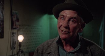 Movie still from “Rocky” (1976), directed by John G. Avildsen – An older man wearing a hat and a jacket; Close Up shot, Low angle