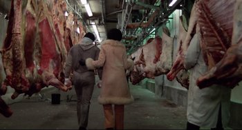Movie still from “Rocky” (1976), directed by John G. Avildsen – Two people walking through a meat market covered in carcasses; Wide shot, Low angle