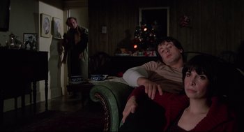 Movie still from “Rocky” (1976), directed by John G. Avildsen – A man sitting on top of a couch next to a woman; Medium shot, Over the shoulder angle