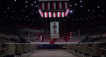 Movie still from “Rocky” (1976), directed by John G. Avildsen – An empty boxing ring in an empty arena; Extreme Wide shot, High angle