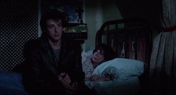 Movie still from “Rocky” (1976), directed by John G. Avildsen – A man and a woman sitting in a bed; Medium shot, Over the shoulder angle