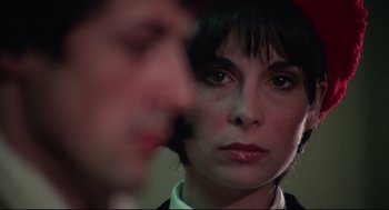 Movie still from “Rocky” (1976), directed by John G. Avildsen – A woman's face and a man's face in the background; Close Up shot, Over the shoulder angle
