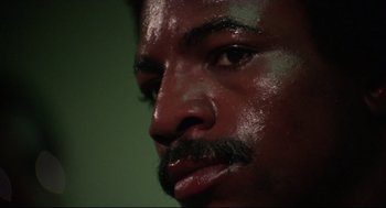 Movie still from “Rocky” (1976), directed by John G. Avildsen – A man's face with a beard; Close Up shot, Low angle