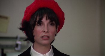 Movie still from “Rocky” (1976), directed by John G. Avildsen – A woman wearing a black jacket and a red hat; Close Up shot, High angle