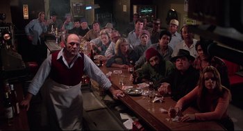 Movie still from “Rocky” (1976), directed by John G. Avildsen – A group of people sitting around a bar; Wide shot, High angle