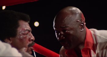 Movie still from “Rocky” (1976), directed by John G. Avildsen – A man in a boxing ring getting ready for a fight; Close Up shot, Low angle