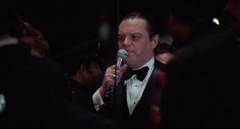 Movie still from “Rocky” (1976), directed by John G. Avildsen – A man in a tuxedo is holding a microphone; Close Up shot, Low angle