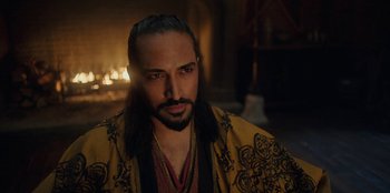 Movie still from “The Witcher” (2019), created by Lauren Schmidt Hissrich – A man with long hair and a beard wearing a robe; Close Up shot, Over the shoulder angle
