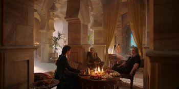 Movie still from “The Witcher” (2019), created by Lauren Schmidt Hissrich – A group of people sitting around a table with candles on it; Wide shot, High angle