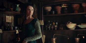 Movie still from “The Witcher” (2019), created by Lauren Schmidt Hissrich – A woman standing in front of a cupboard in a kitchen; Medium shot, Over the shoulder angle