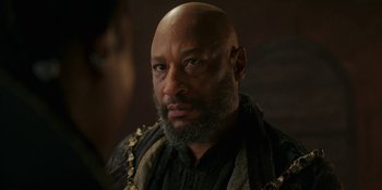 Movie still from “The Witcher” (2019), created by Lauren Schmidt Hissrich – A bald man with a beard and a mustache; Close Up shot, Over the shoulder angle