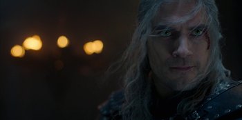 Movie still from “The Witcher” (2019), created by Lauren Schmidt Hissrich – A man with long hair and green eyes; Close Up shot, Over the shoulder angle
