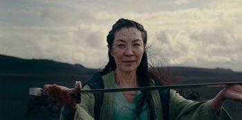 Movie still from “The Witcher” (2019), created by Lauren Schmidt Hissrich – An older asian woman holding a sword in her hands; Close Up shot, Over the shoulder angle