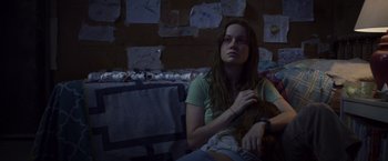 Movie still from “Room” (2015), directed by Lenny Abrahamson – A woman sitting on a couch holding a cat; Medium shot, High angle