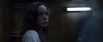 Movie still from “Room” (2015), directed by Lenny Abrahamson – A woman with long dark hair is looking at the camera; Close Up shot, Over the shoulder angle