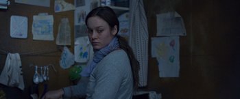 Movie still from “Room” (2015), directed by Lenny Abrahamson – A young woman wearing a blue scarf in front of a wall; Close Up shot, Over the shoulder angle