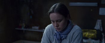Movie still from “Room” (2015), directed by Lenny Abrahamson – A woman sitting in a room looking down at the floor; Close Up shot, Over the shoulder angle