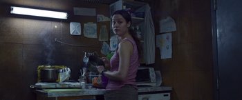 Movie still from “Room” (2015), directed by Lenny Abrahamson – A woman in a pink shirt is holding something in her hand; Medium shot, Low angle