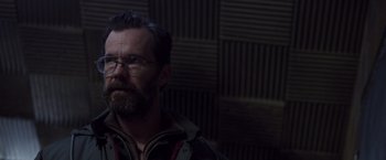 Movie still from “Room” (2015), directed by Lenny Abrahamson – A man with a goatee wearing glasses looking at the camera; Close Up shot, Over the shoulder angle