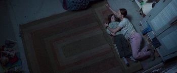 Movie still from “Room” (2015), directed by Lenny Abrahamson – Two young children laying on the floor in a dark room; Wide shot, Overhead angle