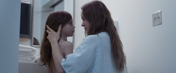 Movie still from “Room” (2015), directed by Lenny Abrahamson – A young woman holding a young girl's head; Close Up shot, Over the shoulder angle