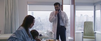 Movie still from “Room” (2015), directed by Lenny Abrahamson – A man in a white lab coat standing in front of a woman; Medium shot, Over the shoulder angle