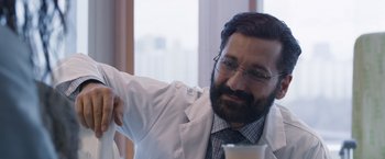 Movie still from “Room” (2015), directed by Lenny Abrahamson – A man in a white lab coat holding a cup; Close Up shot, Over the shoulder angle
