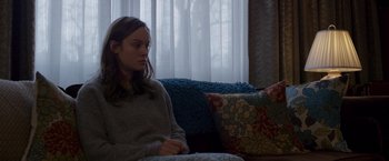 Movie still from “Room” (2015), directed by Lenny Abrahamson – A woman sitting on a couch in front of a window; Medium shot, Over the shoulder angle