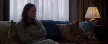 Movie still from “Room” (2015), directed by Lenny Abrahamson – A woman sitting on a couch in front of a window; Medium shot, Over the shoulder angle