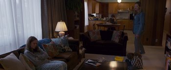 Movie still from “Room” (2015), directed by Lenny Abrahamson – A living room filled with couches and a table; Wide shot, Over the shoulder angle