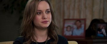 Movie still from “Room” (2015), directed by Lenny Abrahamson – A woman sitting on a couch in front of a picture; Close Up shot, Over the shoulder angle