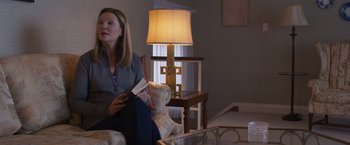 Movie still from “Room” (2015), directed by Lenny Abrahamson – A woman sitting on top of a couch in a living room; Medium shot, Over the shoulder angle