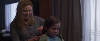 Movie still from “Room” (2015), directed by Lenny Abrahamson – A young girl getting her hair cut by an adult; Medium shot, Over the shoulder angle