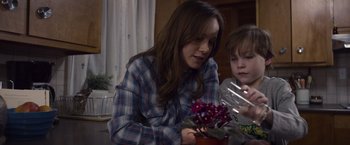 Movie still from “Room” (2015), directed by Lenny Abrahamson – A woman and a boy are looking at a plant; Close Up shot, Over the shoulder angle