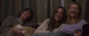 Movie still from “Room” (2015), directed by Lenny Abrahamson – Two people sitting on a bed laughing and smiling; Medium shot, Over the shoulder angle