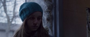 Movie still from “Room” (2015), directed by Lenny Abrahamson – A woman wearing a blue hat looking at the camera; Close Up shot, Low angle