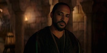 Movie still from “The Witcher” (2019), created by Lauren Schmidt Hissrich – A person with a beard wearing a necklace; Close Up shot, Over the shoulder angle