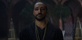 Movie still from “The Witcher” (2019), created by Lauren Schmidt Hissrich – A person with a beard wearing a necklace; Close Up shot, Low angle